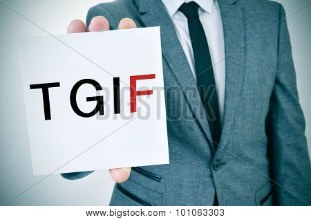 a young man in suit shows a signboard with the word TGIF, Thanks God It is Friday, written in it