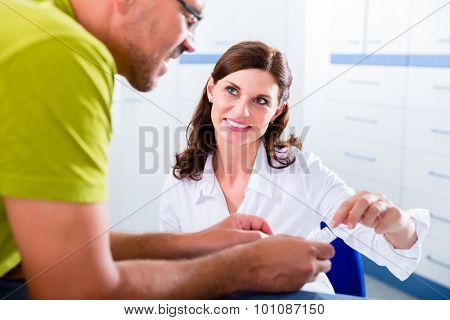 Doctors nurse with telephone in front desk making appointment with patient