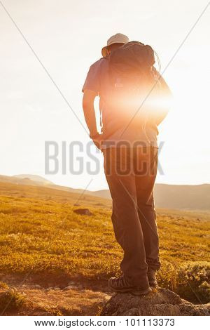 hiker with backpack traveling in Norway mountains Dovre