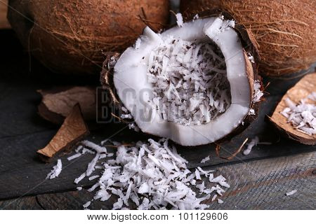 Coconut shavings in coconut on wooden background