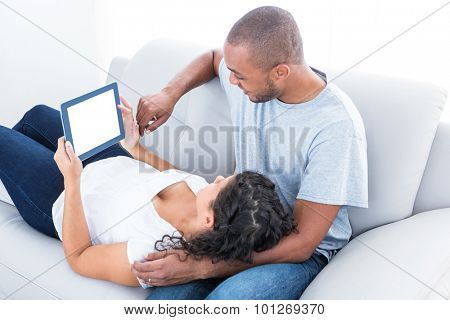 Couple enjoying with laptop relaxing on sofa at home