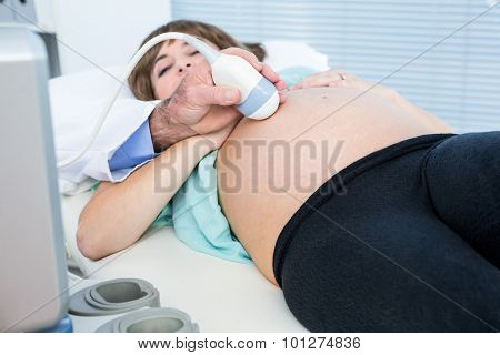 Midsection of male doctor doing ultrasound test in clinic