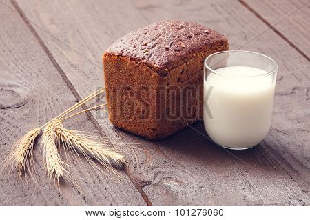 Freshly Baked Bread With Milk And Wheat On A Wooden Boards.