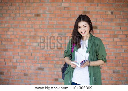 Happy Asian Woman Relaxing Outdoor And Reading Book