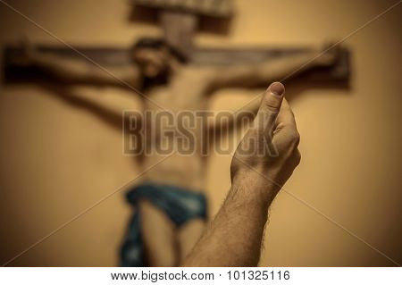Artitic Vignette Edit Of A Man's Hand Raised Towards Jesus On The Cross