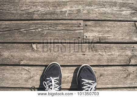 First persn perspective of wooden boardwalk and shoes