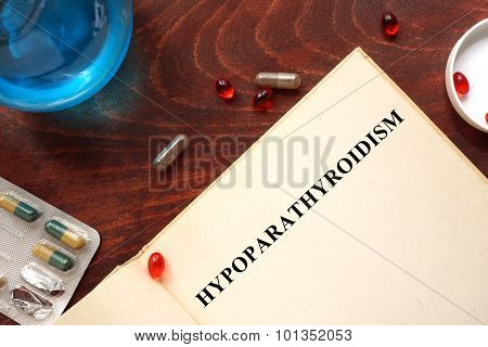 Hypoparathyroidism written on book with tablets.