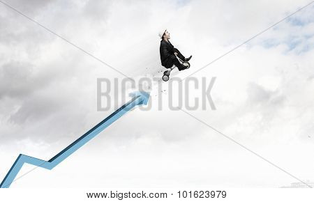 Young funny businessman riding three wheeled bicycle