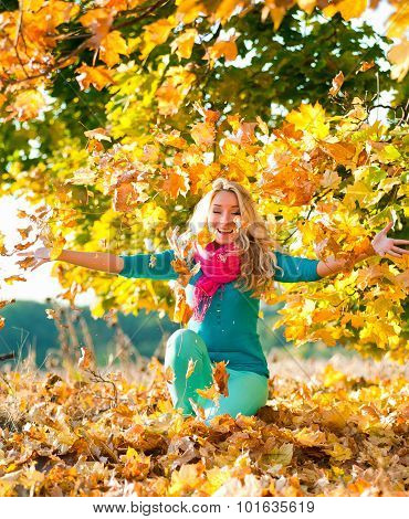 Beautiful Girl Relaxing In Autumn Park Throwing Leaves