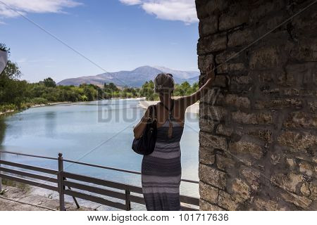 Woman Standing On The Bridge Looking At The View Of Arachthos River Of Arta City, Epirus Greece
