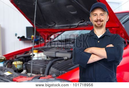 Smiling repairman with tire wrench in car repair service.