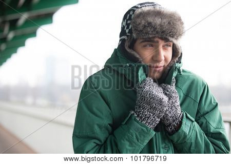 Man in warm clothing shivering outdoors