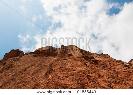 Steep Mountain And Cloudy Blue Sky