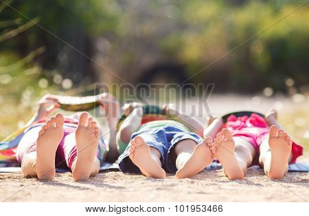 Children lie on the ground in the Park and eat watermelon