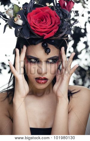pretty brunette woman with rose jewelry, black and red, bright make up kike a vampire closeup