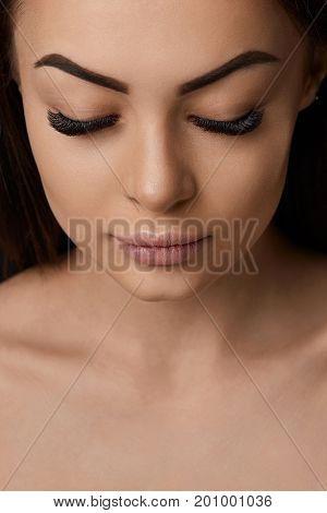 Eyelashes extensions. Fake Eyelashes. Closeup Of Beautiful Young Female Model With Soft Smooth Skin And Professional Facial Makeup. Portrait Of Sexy Girl With Long Fake Eyelashes And Perfect Make-up.