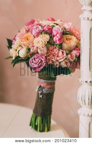 Bridal Bouquet With Pink Roses And Peach Peonies Stands On Background Of Vintage Wall