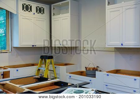 Installation of kitchen. Custom kitchen cabinets in various stages of installation base for island in center