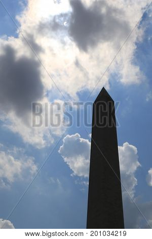 Solar eclipse in Washington DC USA. Partially blocked sun seen through clouds above Washington Monument.