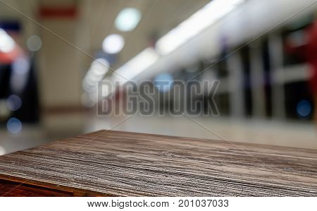 Empty wooden table space platform and blurred coffee shop where working and meeting place background for product display montage. Selective focus.