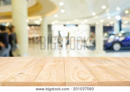 Empty wooden table space platform with blurred shopping mall or shopping center background for product display montage. Wooden desk with copy space.