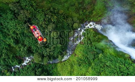 Tourists are playing zip line waterfall in LaosRainforest Asia.It's an adventurous event.People are sitting on a sling.Happy to appreciate the strange nature. Freedom Top view Aerial view
