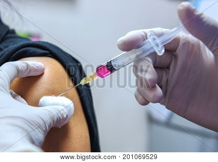 Close-up handsnurses are vaccinations to patients using the syringe.Doctor vaccinating women in hospital.Are treated by the use of sterile injectable upper arm. injection