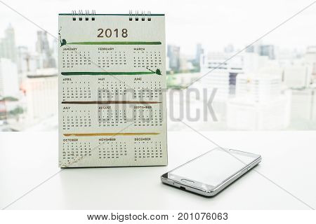 creative design 2018 calendar with smartphone on office desk