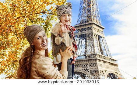 Mother And Child Travelers Handwaving On Embankment In Paris