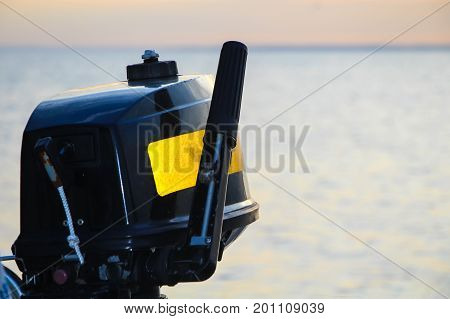 Black and yellow motor for the rubber boat and sea.