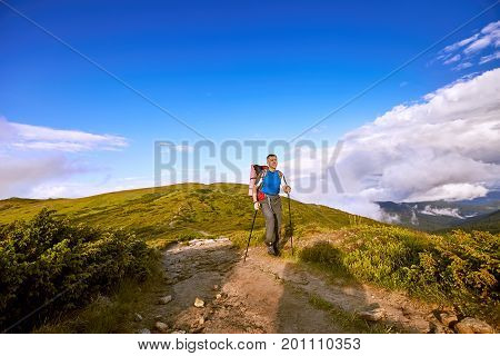 Hiking in the mountains with a backpack in the summer.