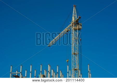 Builders with crane building a concrete house