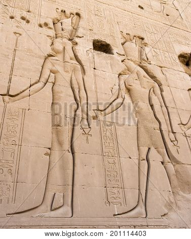 Egyptian figures carved on the yellow wall