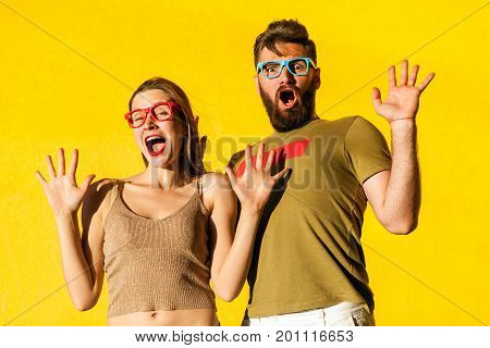 Its not me! Funny couple grimacing shocked and looking at camera. Isolated on yellow background studio shot