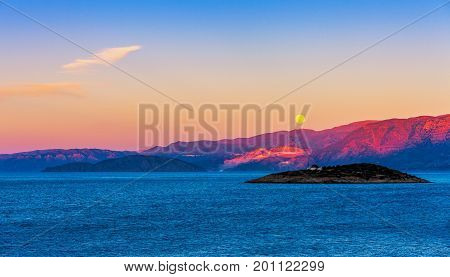 Full moon over the island of Crete at sunset Mirabello Bay Crete Greece