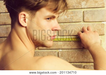 Man With Naked Body Holds Yellow Self Retracting Tape Measure