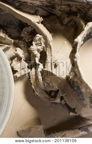 pottery, workshop, ceramics art concept - some fireclay and water around the Potter's wheel are reused as raw materials for new products, top view, close-up