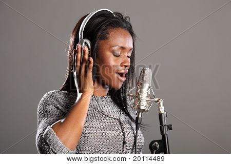 Het maken van muziek mooie zwarte vrouw zang In Mic