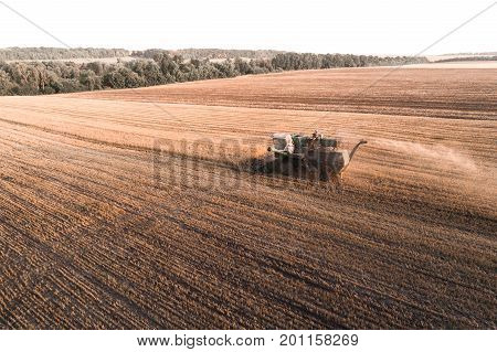 Harvester machine working in field . Combine harvester agriculture machine harvesting golden ripe wheat field. Agriculture. Aerial view. From above.