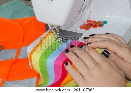Woman hand on sewing machine.Dressmaker work on the sewing machine. Hobby sewing fabric as a small business concept. Female tailor threading leather material on sewing machine