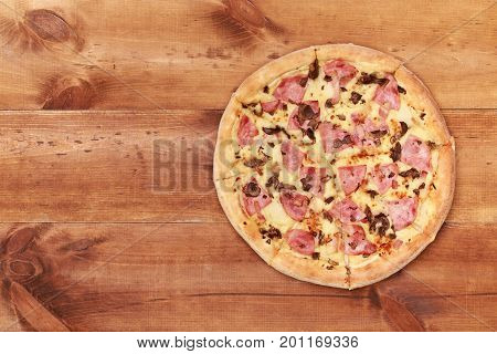 Pizza on wooden. Wooden table top view. On the table are the food for cooking. Healthy food. Dietetic foods. Above view on food. Hot Homemade Pepperoni Pizza Ready to Eat