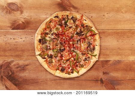 Pizza on wooden. Wooden table top view. On the table are the food for cooking. Healthy food. Dietetic foods. Above view on food. Hot Homemade Pepperoni Pizza Ready to Eat