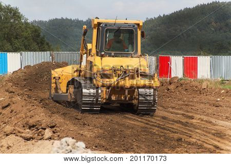 Excavator working on a construction site. Yellow Construction bulldozer at Work. Construction of a new road