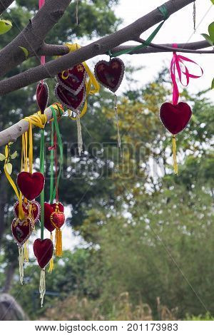 Red hearts hung on a tree using colorful ribbon at Cangshan Mountain in Dali in Yunnan Province of China.