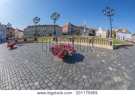 TIMISOARA ROMANIA - AUGUST 24 2017: View of one part at Union Square in Timisoara Romania with old buildings. Trinity Statue and serbian vicariate in background.