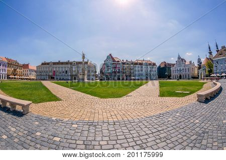 TIMISOARA ROMANIA - AUGUST 24 2017: View of one part at Union Square in Timisoara Romania with old buildings. Trinity Statue and serbian vicariate in background.
