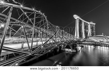 Singapore, Singapore - July 21, 2017: View at the Marina Bay in Singapore during the night with the iconic landmarks of The Helix Bridge.