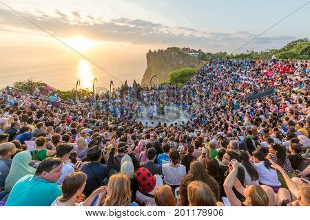 Bali, Indonesia - August 24, 2017: Tourists watch traditional Balinese Kecak Dance at Uluwatu Temple on Bali, Indonesia. 
Kecak Dance at Uluwatu Temple on Bali is very popular cultural show on Bali.