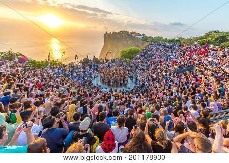 Bali, Indonesia - August 24, 2017: Tourists watch traditional Balinese Kecak Dance at Uluwatu Temple on Bali, Indonesia. 
Kecak Dance at Uluwatu Temple on Bali is very popular cultural show on Bali.
