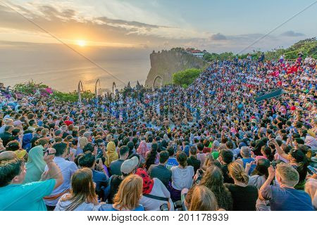 Bali, Indonesia - August 24, 2017: Tourists watch traditional Balinese Kecak Dance at Uluwatu Temple on Bali, Indonesia. 
Kecak Dance at Uluwatu Temple on Bali is very popular cultural show on Bali.
